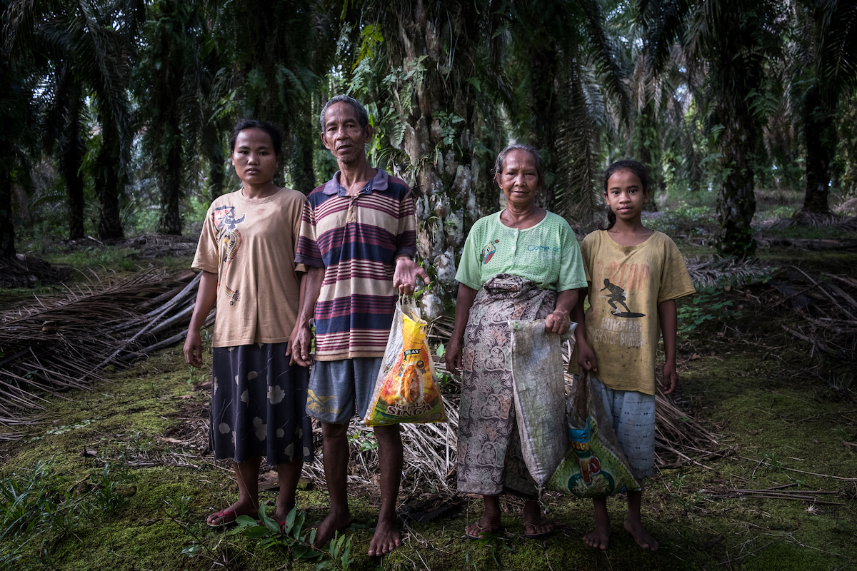 Ridah, Cilin, Siti Maninah and Yenita, members of the Suku Anak Dalam, standing in a plantation in South Sumatra.