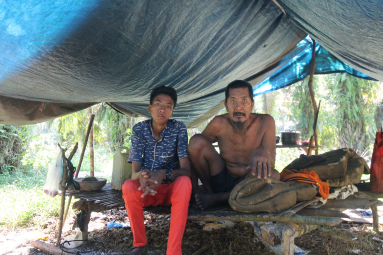 Roki and his father, Nering, who live in a corner of the Orang Rimba community's palm oil plantation. They both have a chronic cough.