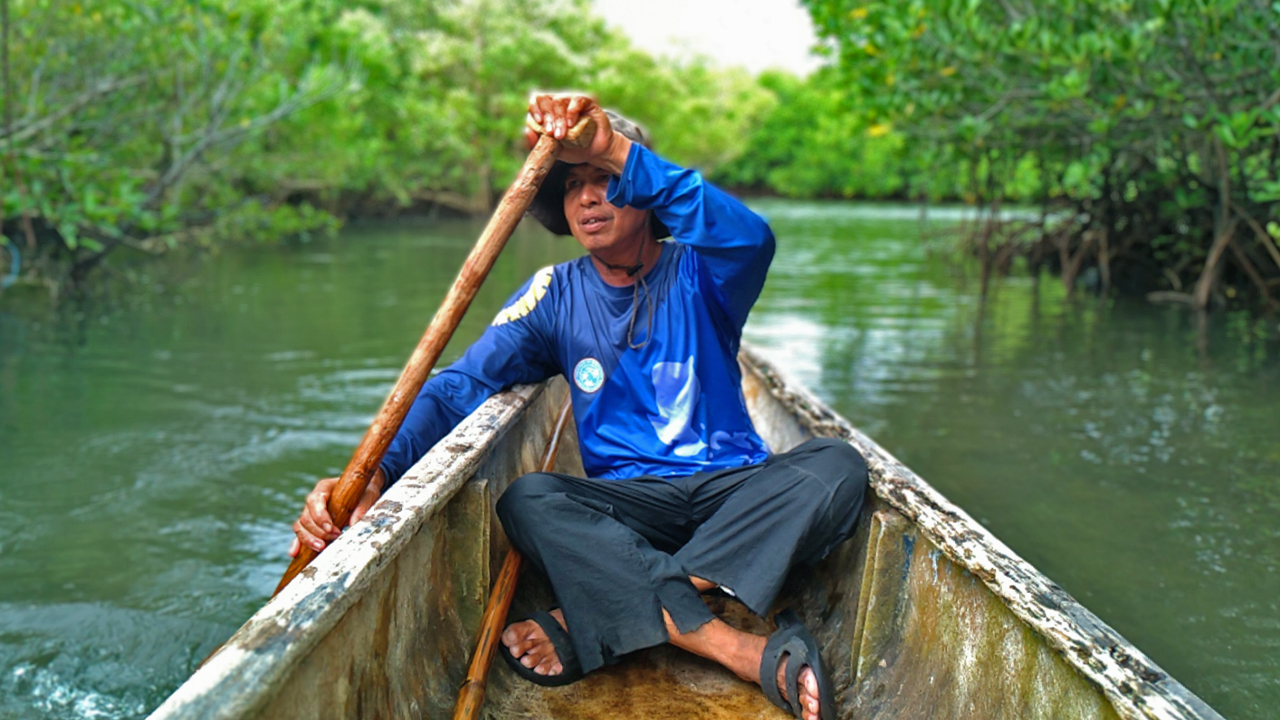 Victor Emata, a SEAMANCOR-trained tour guide, rowing a boat.