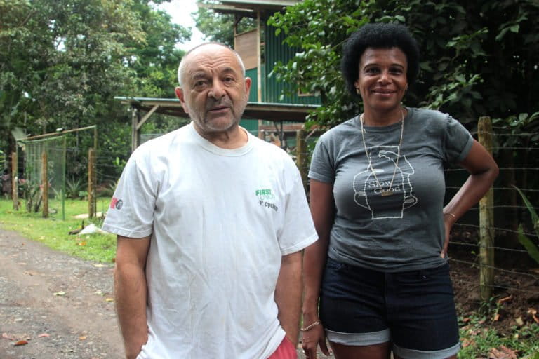 Ana Baltodano and Michael Chizkov in front of their house. The couple contacted the Sloth Conservation Foundation to ask for a bridge to connect the trees to help sloths and other wildlife move safely. Image by Monica Pelliccia for Mongabay.